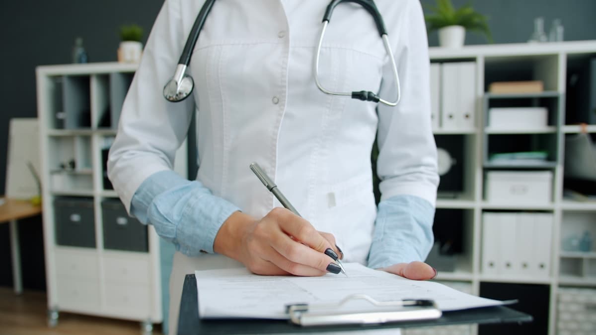 Physician reviewing a clipboard of patient records