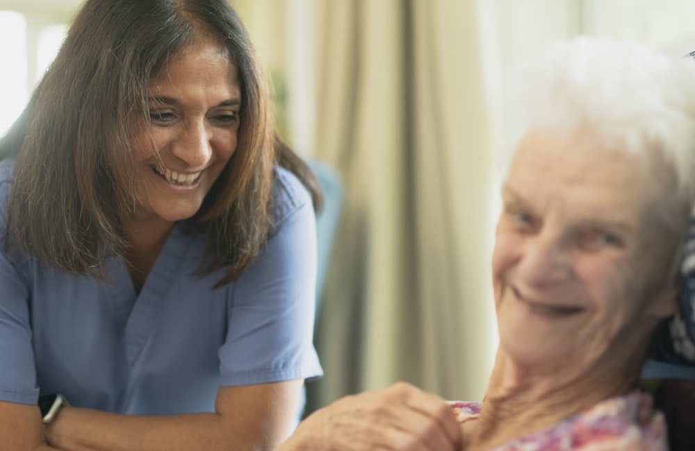 Doctor visiting an elderly patient at home, discussing care in the living room