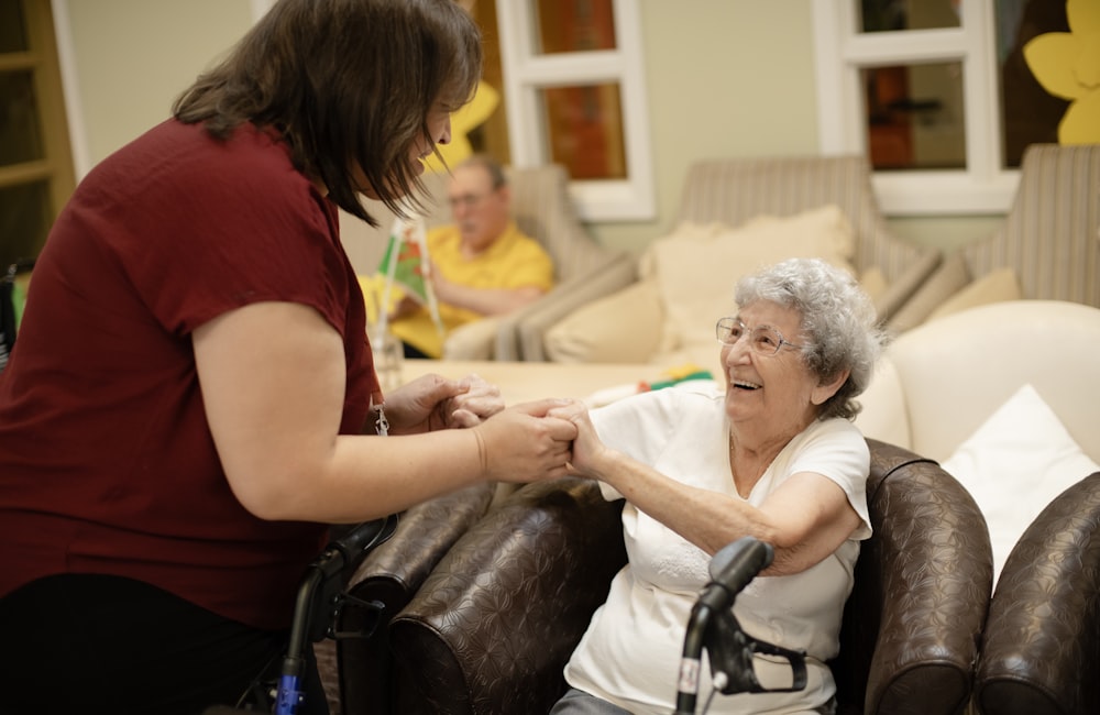 Caregiver helping an elderly patient with mobility support at a care facility